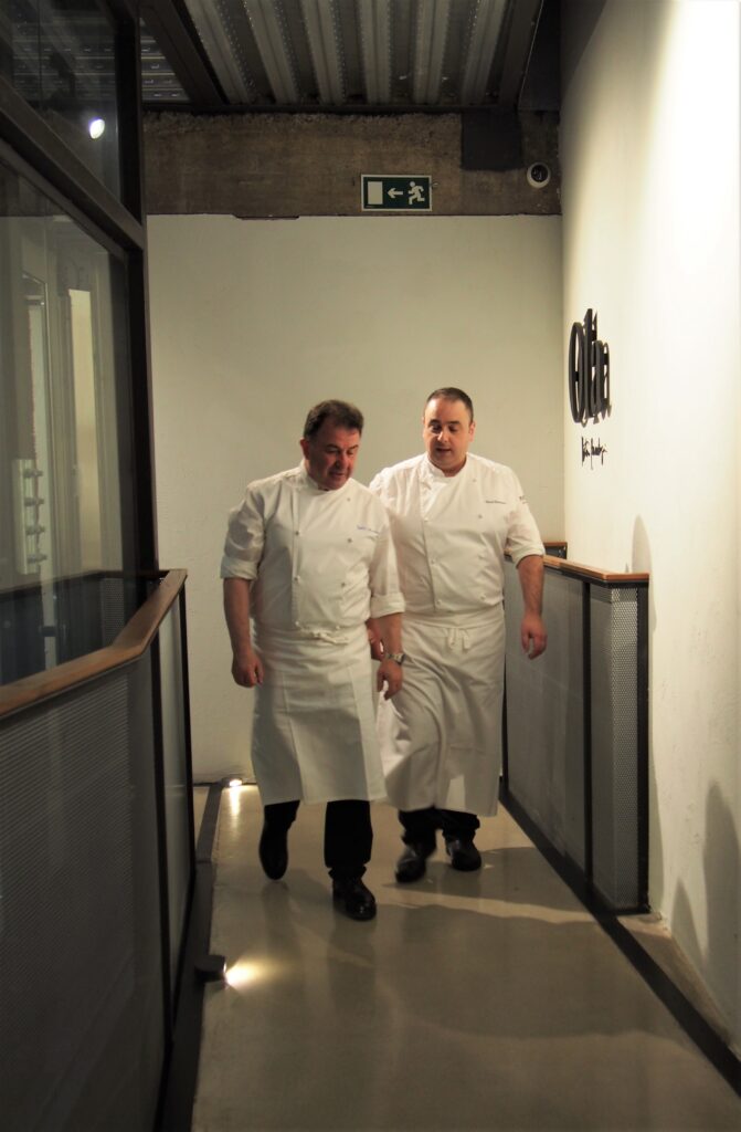 Martín Berasategui and Pintxo walking through the corridors of Tayko Bilbao on their way to the Ola Martín Berasategui restaurant